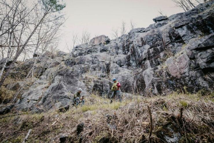 landscape of two students readying ropes to climb an ice-field rock face